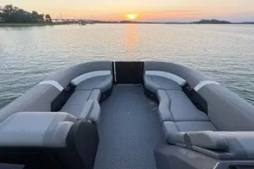 Boat interior facing lake and sunset with calm water.