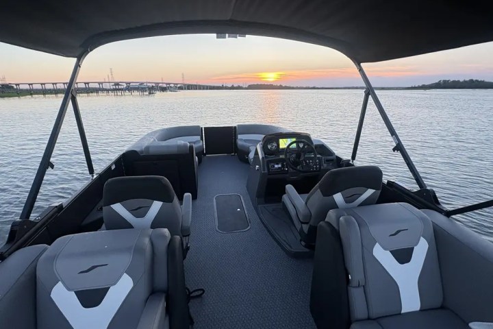 Pontoon boat interior at sunset on calm water.